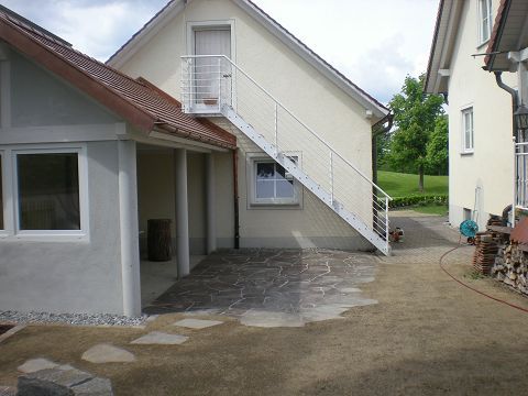 Ein weißes Haus mit einer Treppe, die in den zweiten Stock führt