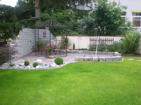 Ein üppiger grüner Rasen mit einem Pavillon im Hintergrund