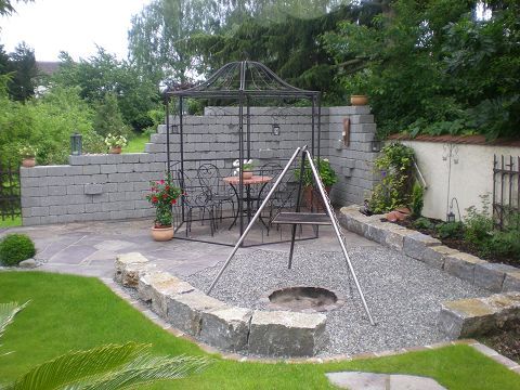 Eine Terrasse mit Tisch und Stühlen und einer Feuerstelle