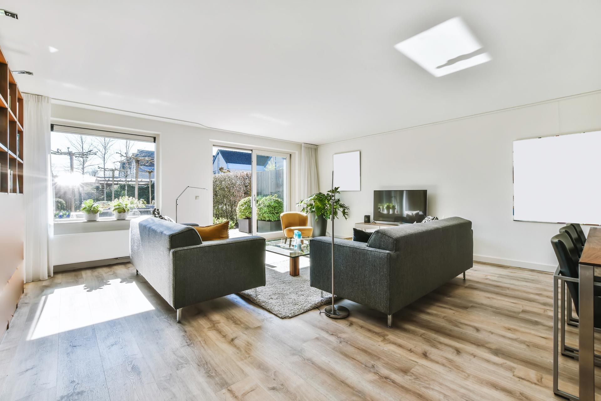 Living room with two gray sofas, wood floors, and access to a patio.