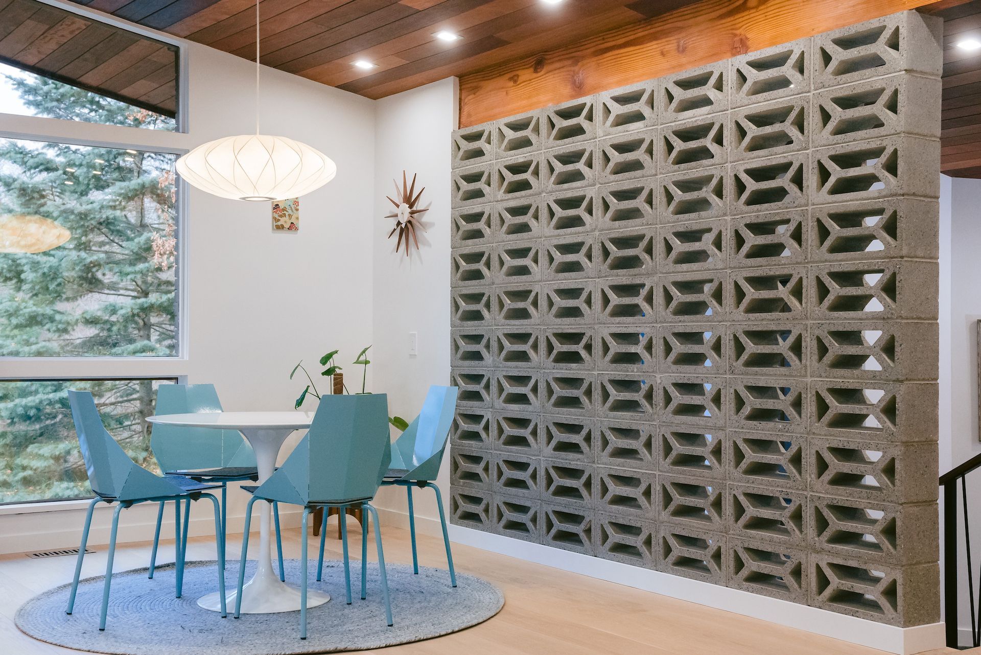 A dining room with a table and chairs and a brick wall.