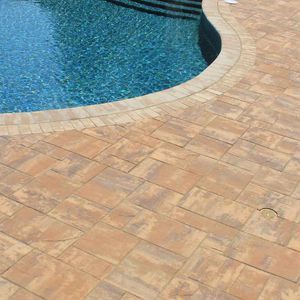 A swimming pool with a brick patio around it.