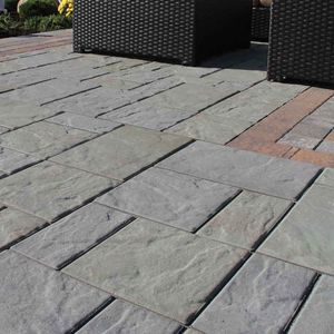 A patio with wicker chairs and a table on it.