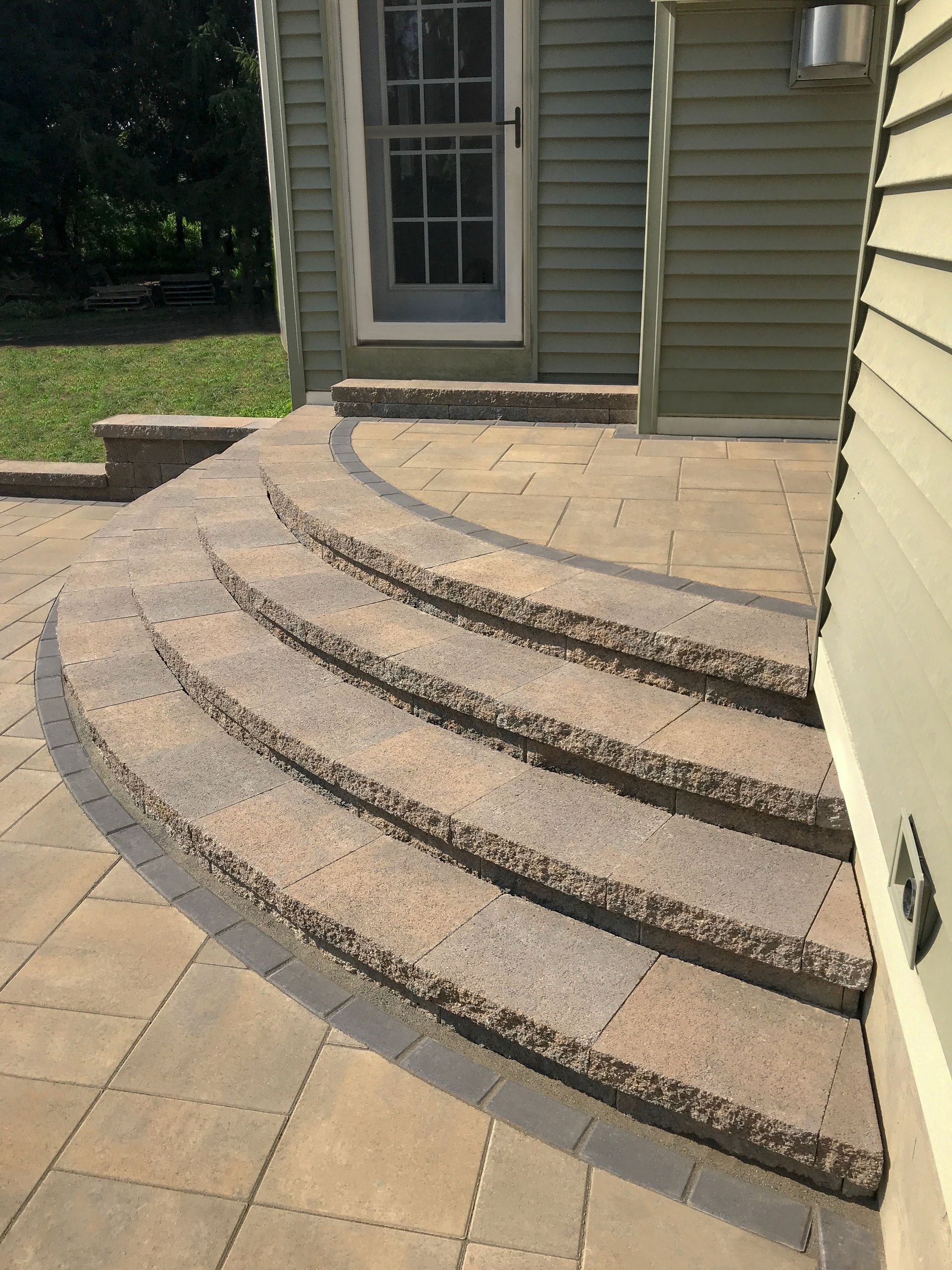 A patio with curved steps leading up to a house.