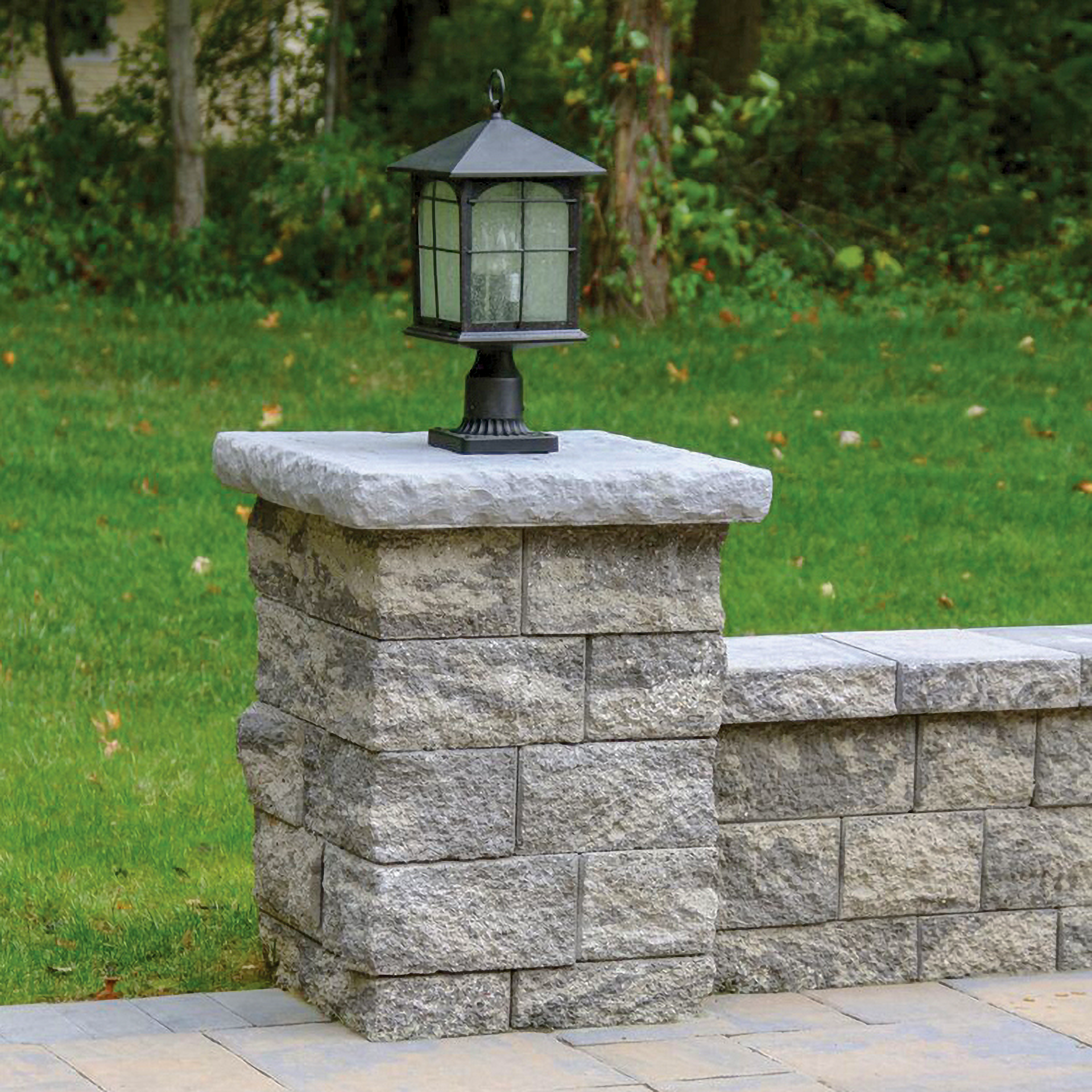 A stone pillar with a lamp on top of it