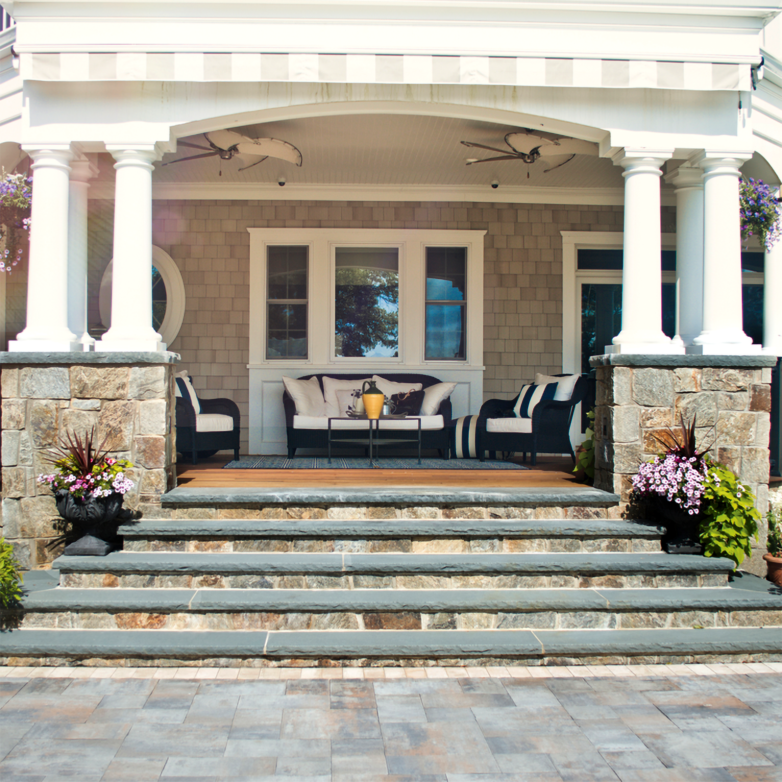 A porch with a couch and chairs on it