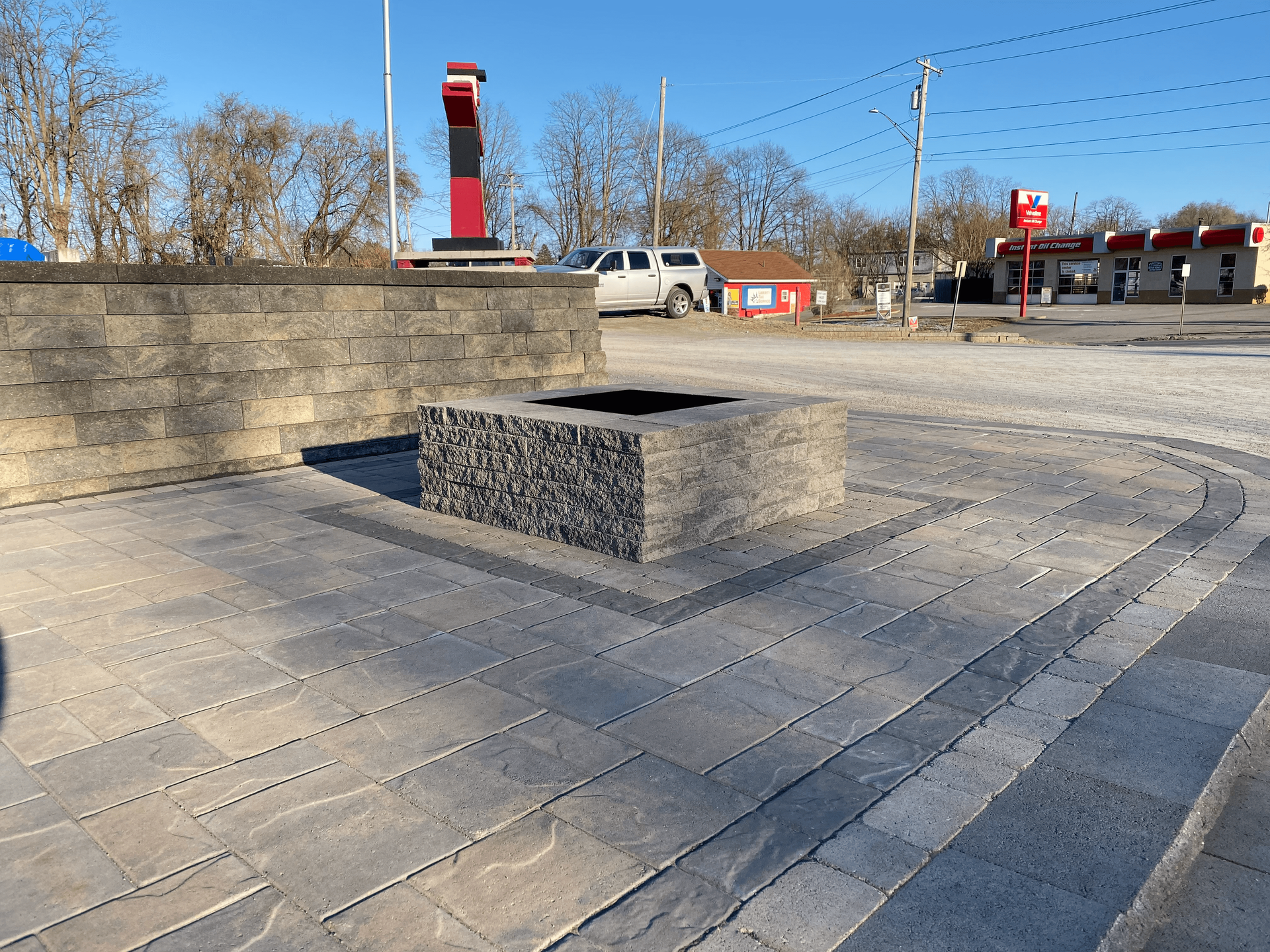 A brick wall with a fire pit in the middle of it