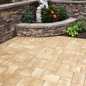 A patio with a stone wall and a statue in the middle of it.