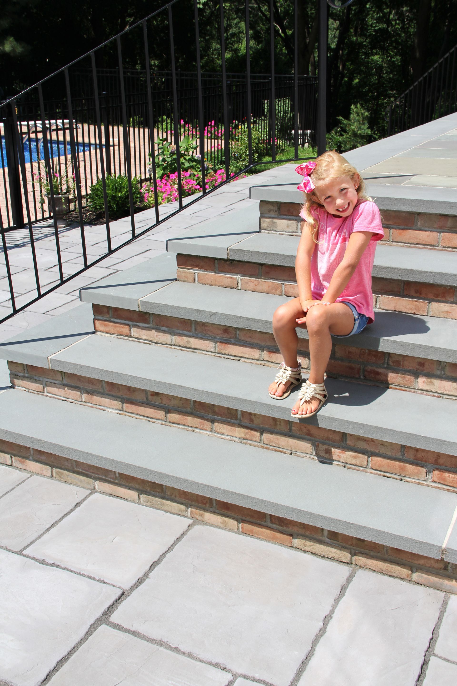 A little girl is sitting on a set of stairs.