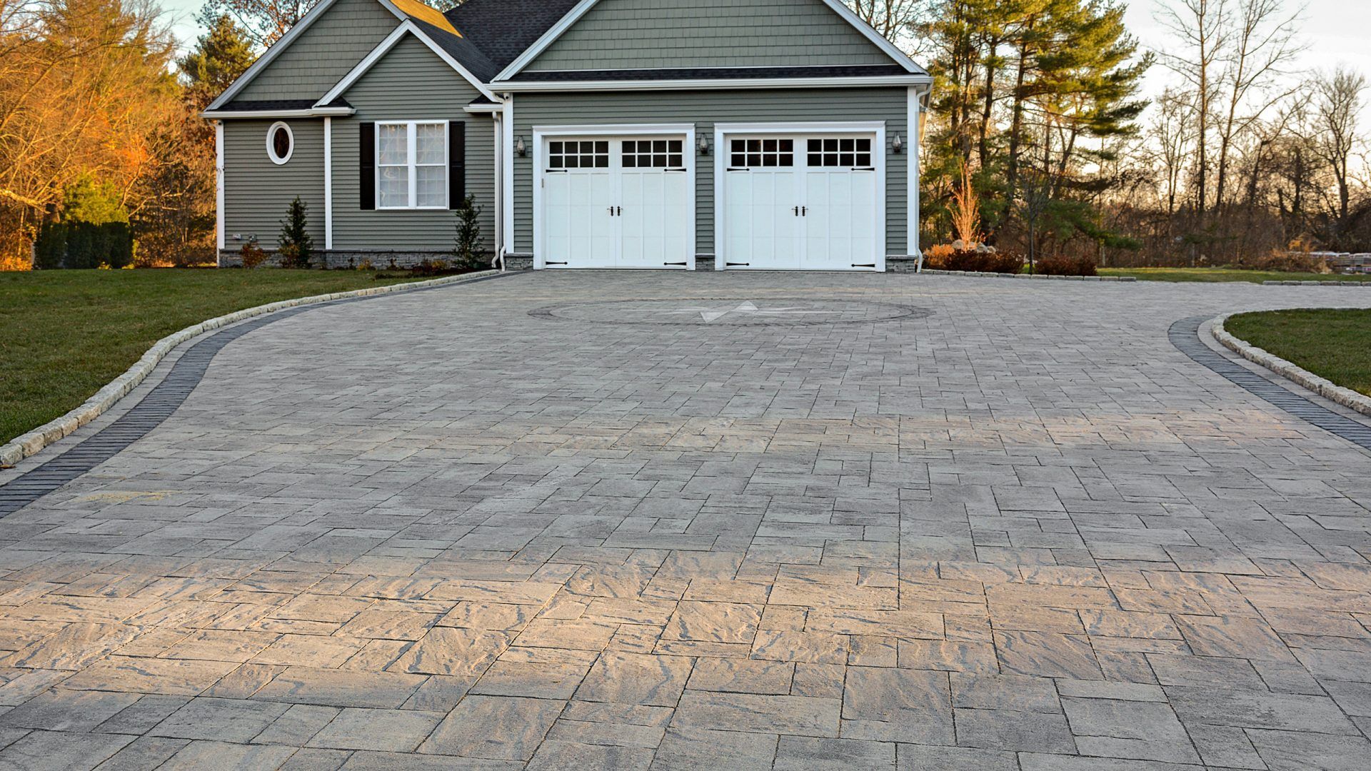 A driveway leading to a house with two garage doors