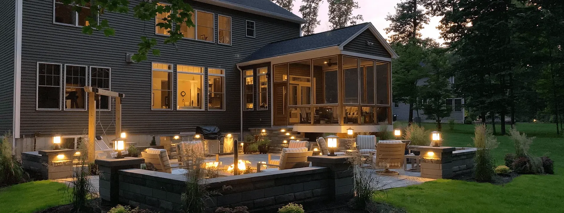 A large house with a screened in porch and patio at night.