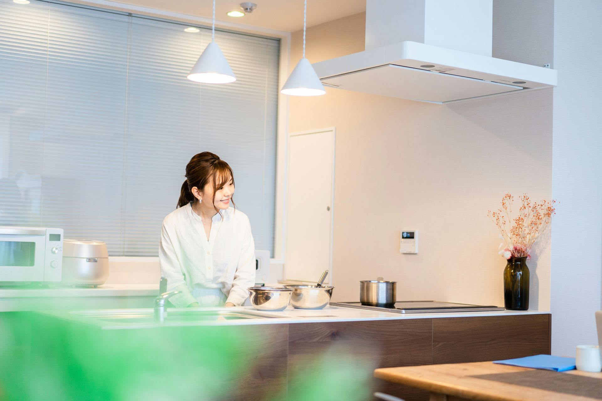 A woman is standing in a kitchen preparing food.
