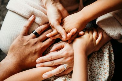A group of people are putting their hands together.