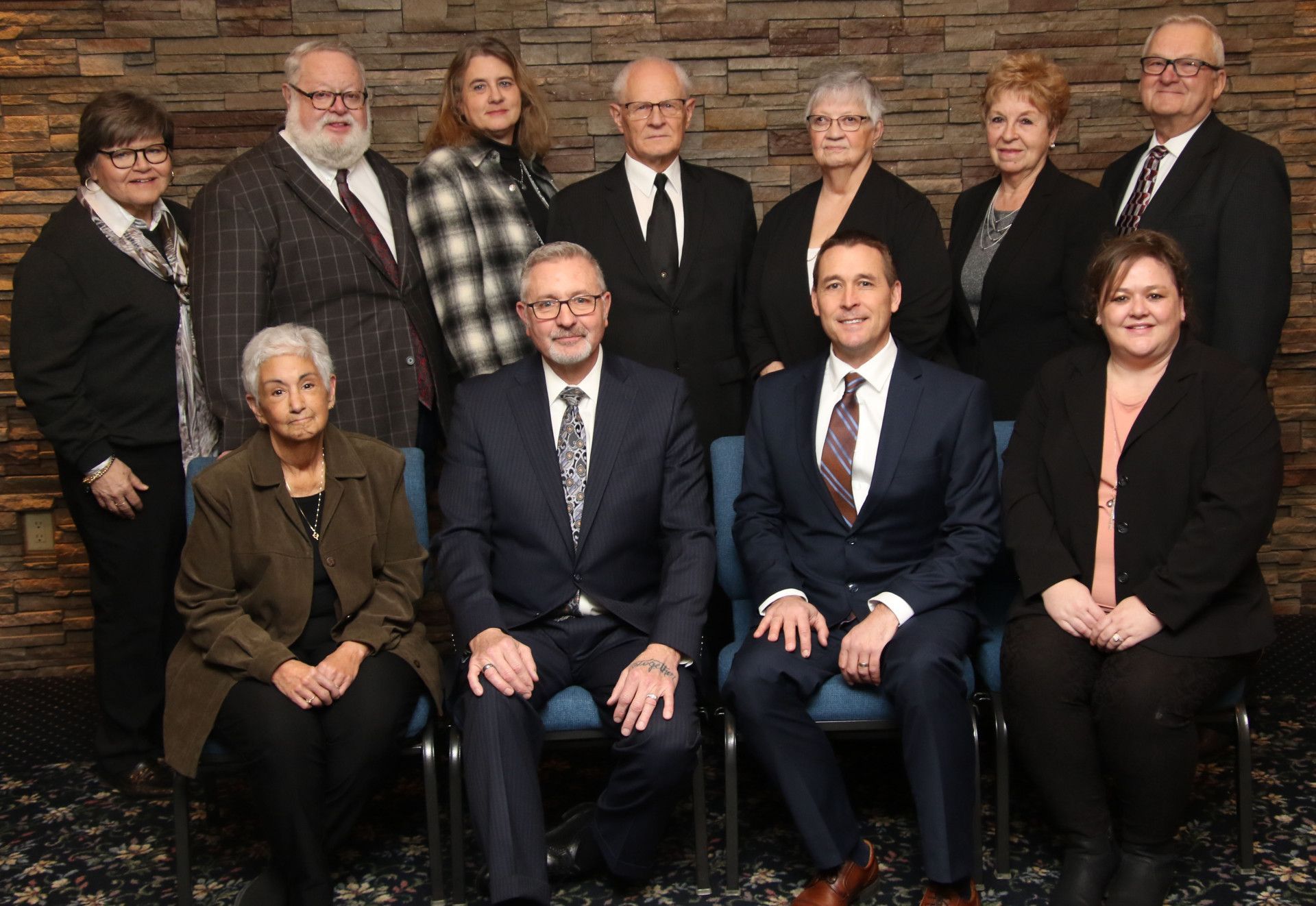 A group of people in suits and ties are posing for a picture.