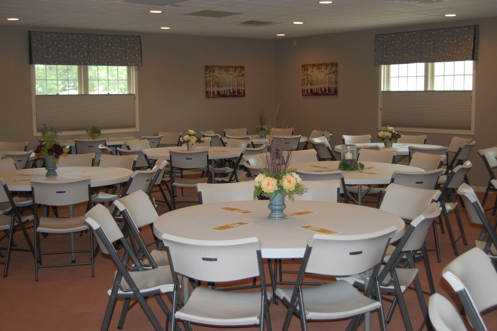 A large room with tables and chairs set up for a party