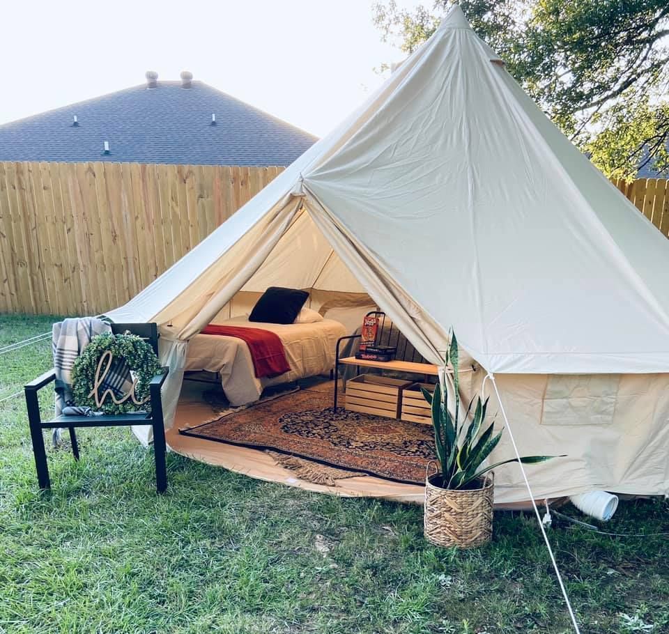 a tent with a bed and a chair in it is in the backyard | proposals