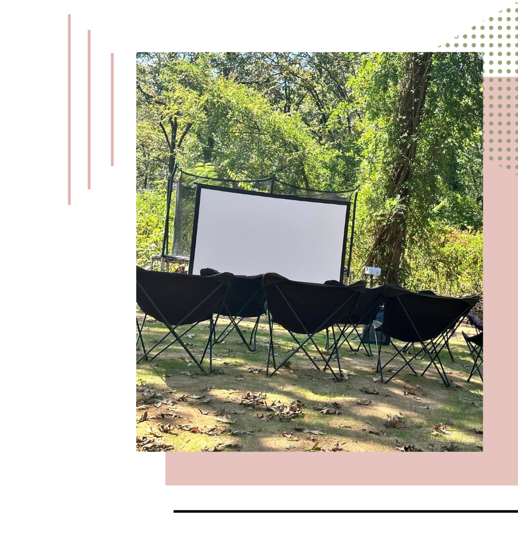 a projector screen is sitting in the middle of a park surrounded by chairs  | sleeping tent hire