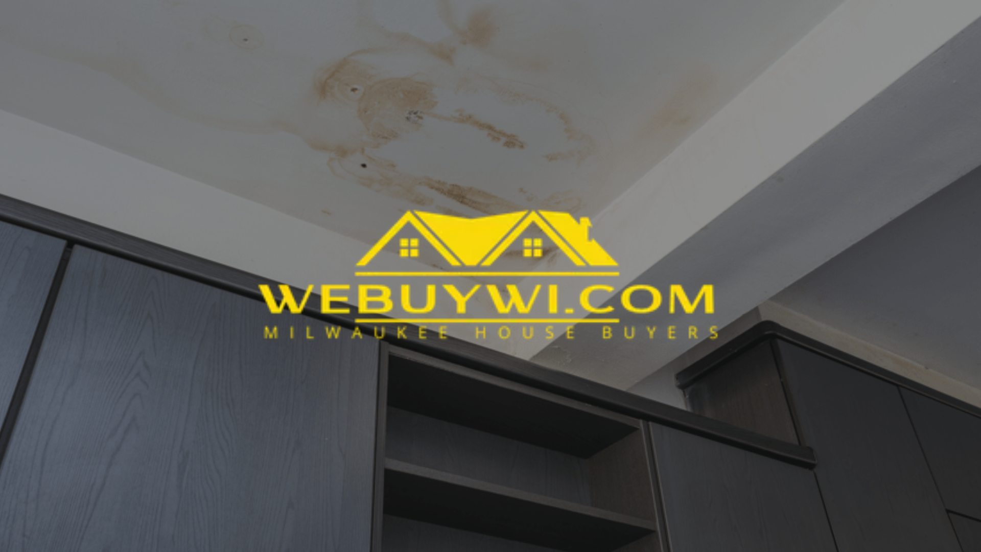 Water-stained greenfield wi ceiling with dark cabinetry below, likely indicating a leak or past water damage. The website logo WEBUYWI.COM overlays the image.