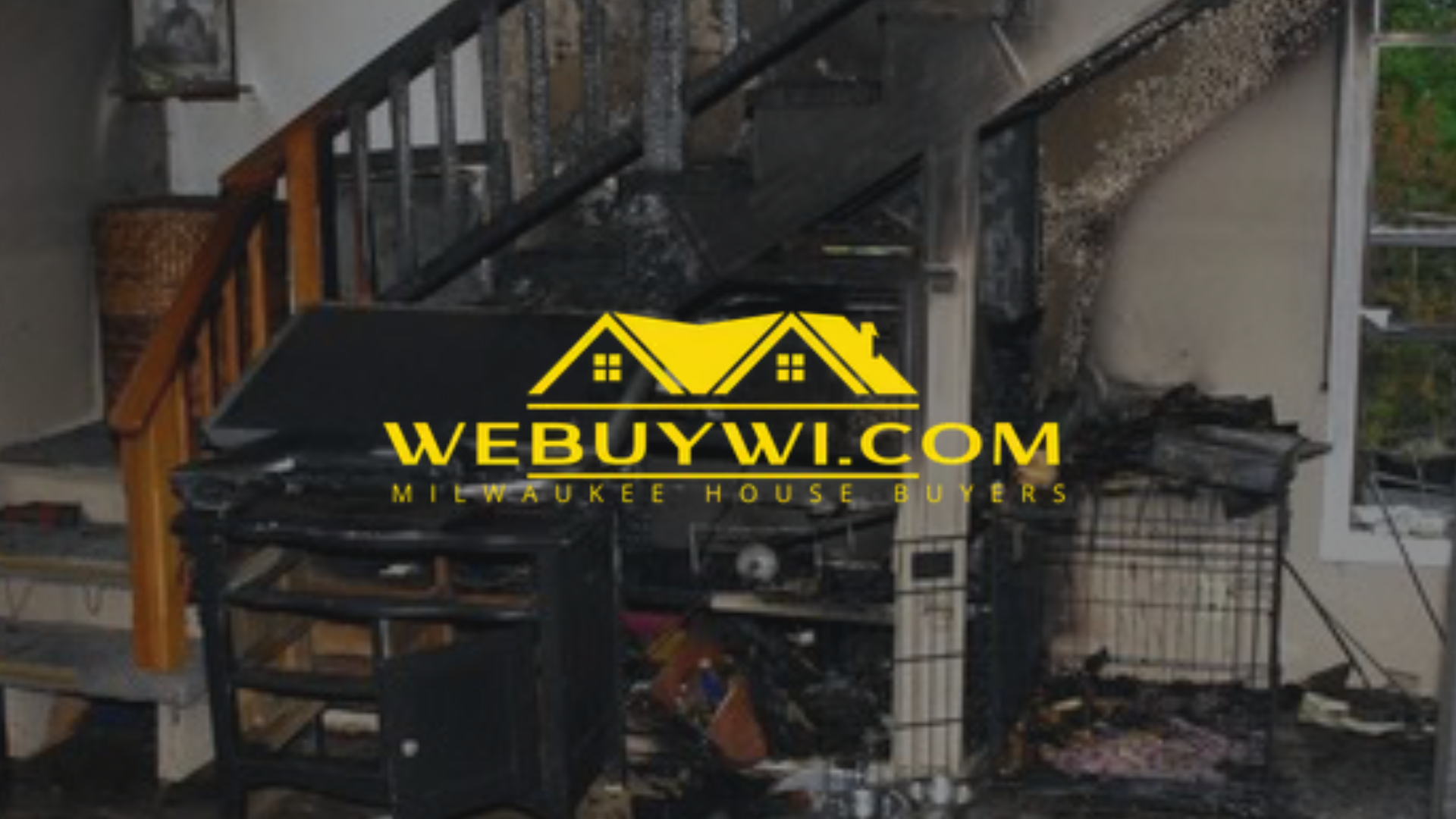 A greenfield wi staircase and surrounding interior show extensive fire damage, with charred wood, debris, and a burned appliance in the foreground.