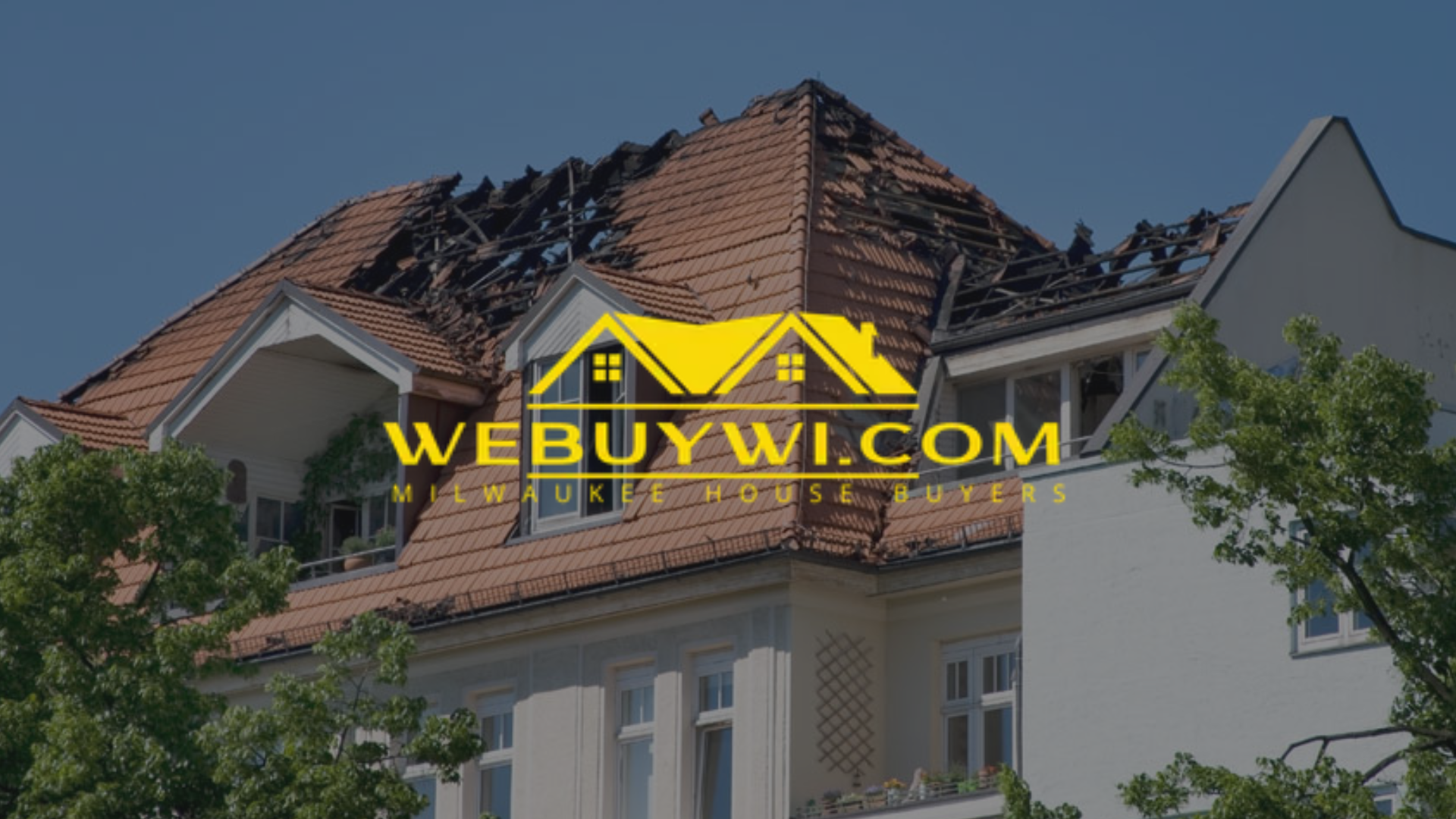 A greenfield wi house with a burnt roof, the sky is blue, with a 