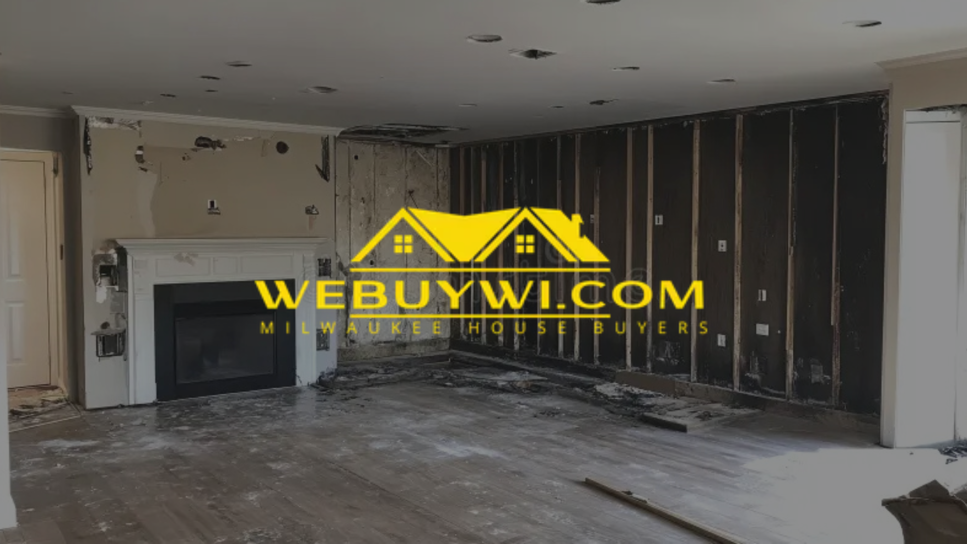 Interior demolition of a room with exposed framing, fireplace, and debris.