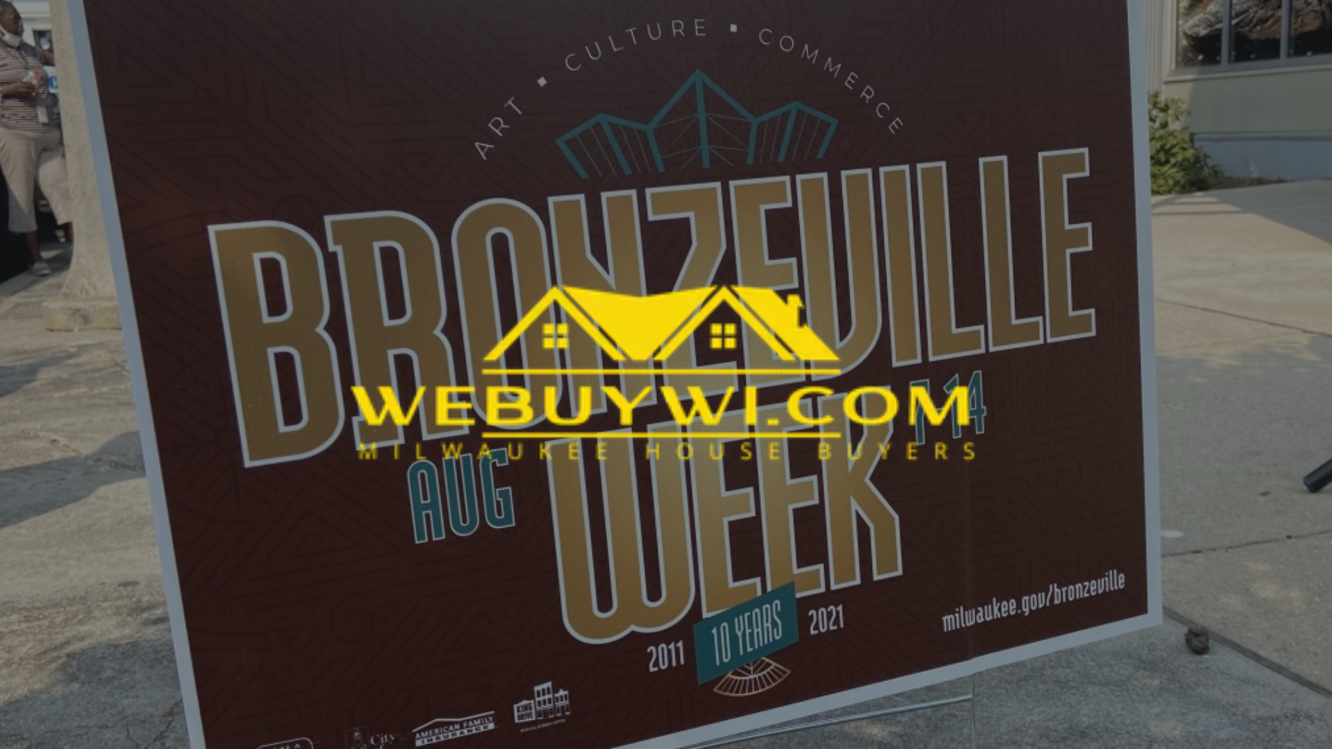 Sign for Bronzeville Week with a WeBuyWI.com watermark.