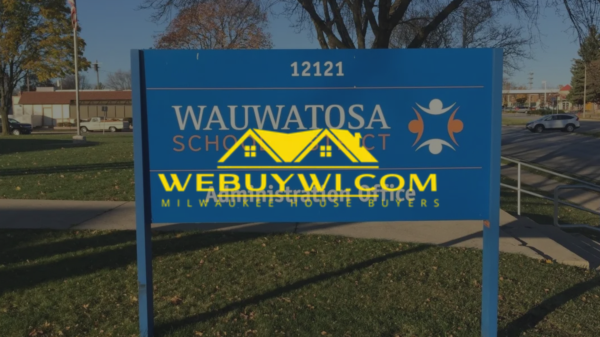Sign for Wauwatosa School District. The blue sign has white text and a logo. A website address is also listed.