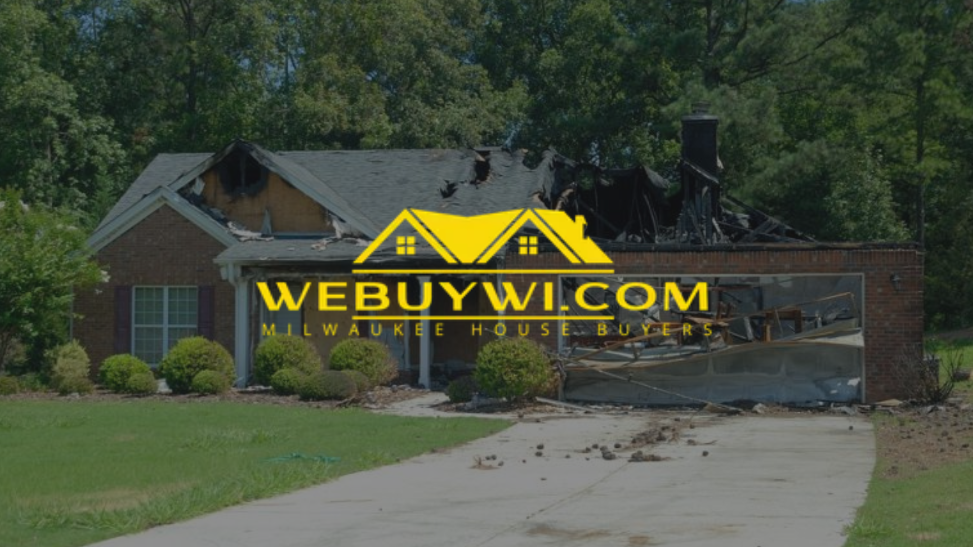 House with fire damage, garage, and driveway. Logo
