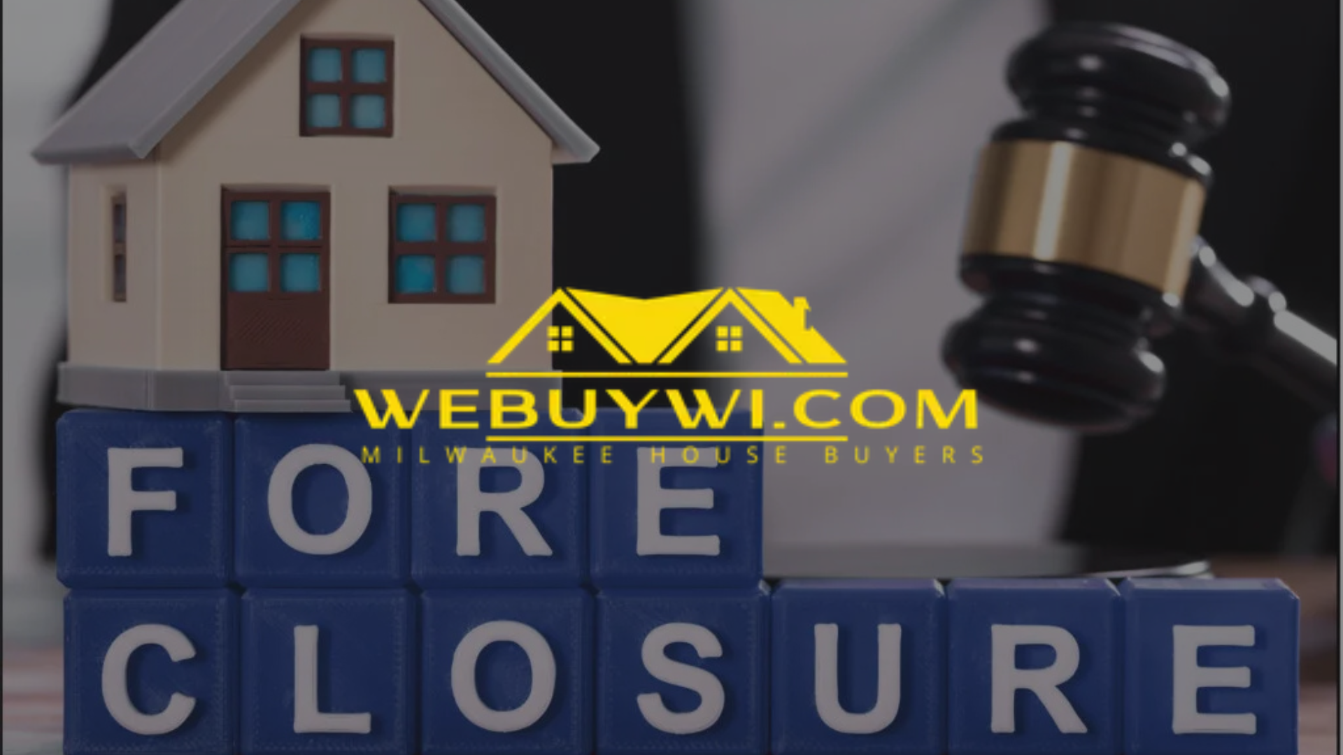 A miniature house and gavel rest atop blocks spelling 