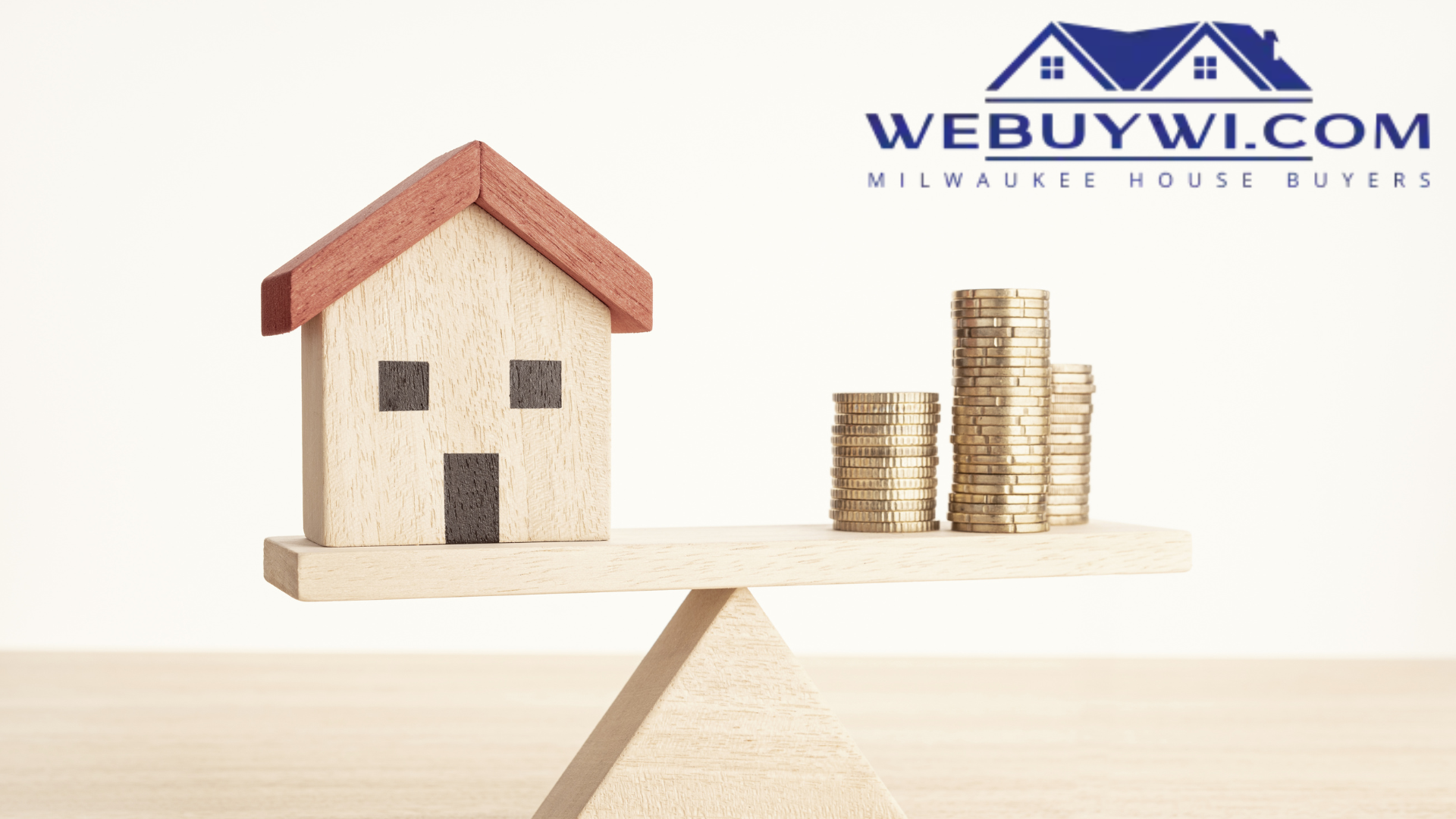 A house and stacks of coins are on a wooden scale.