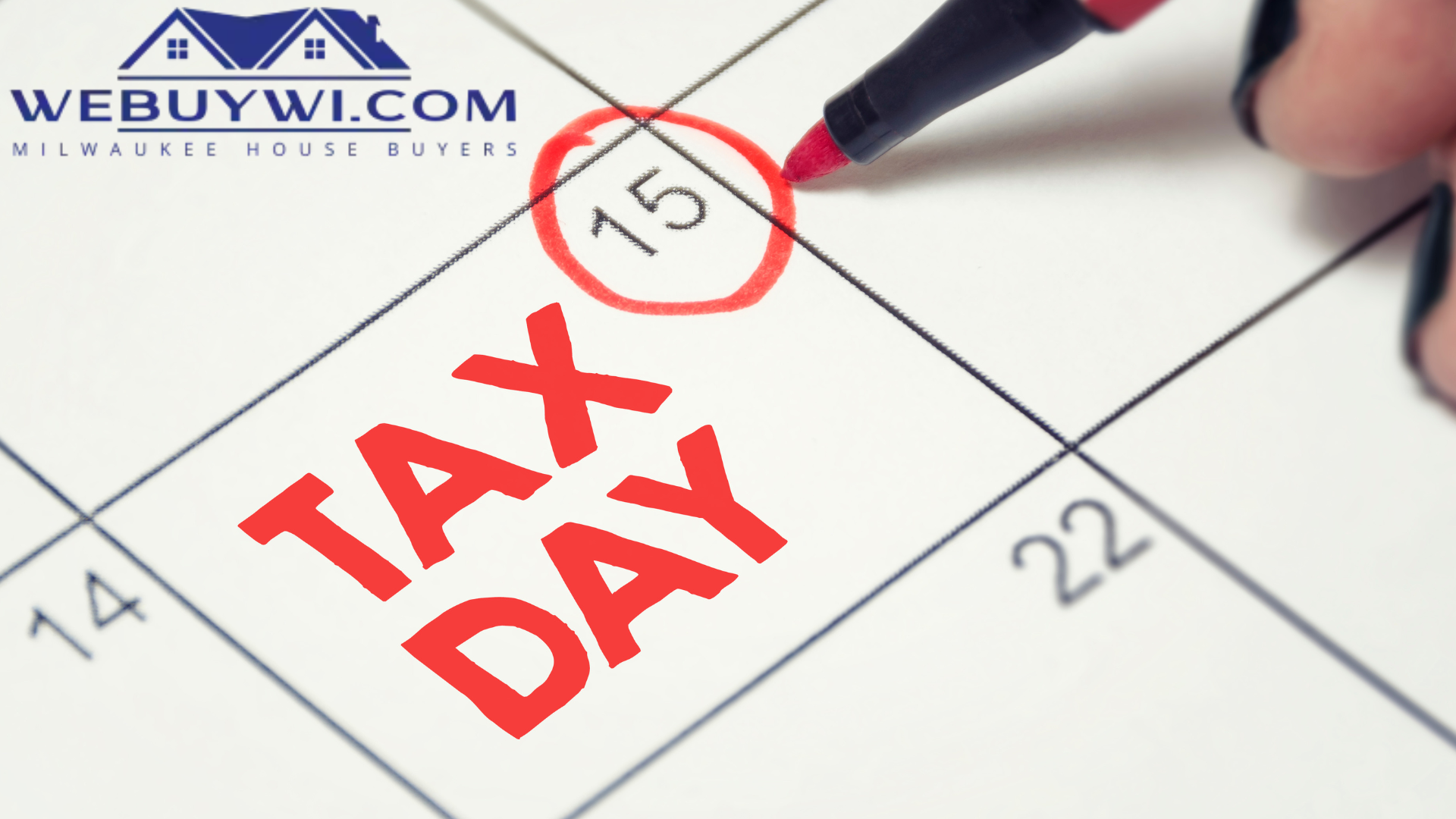 A person is writing tax day on a calendar
