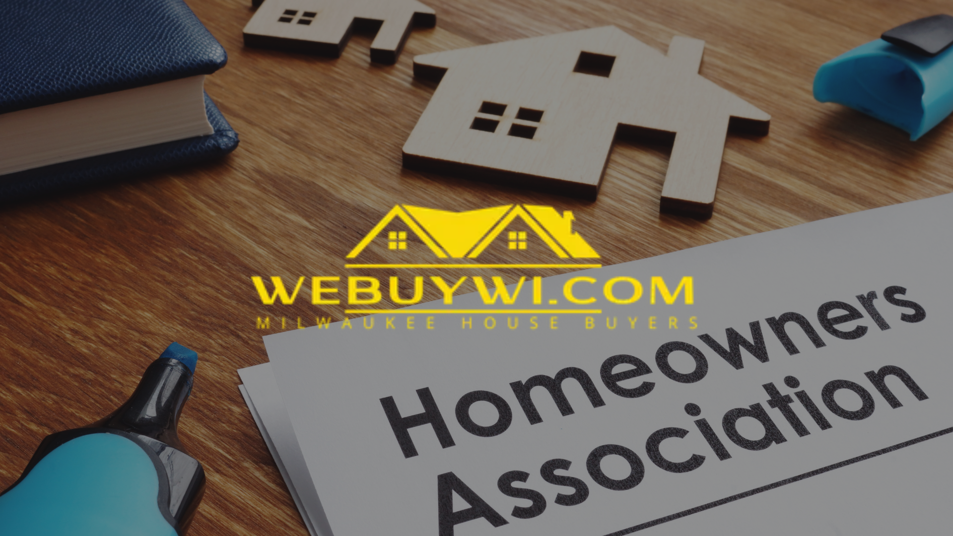 Wooden houses and book on wooden surface with