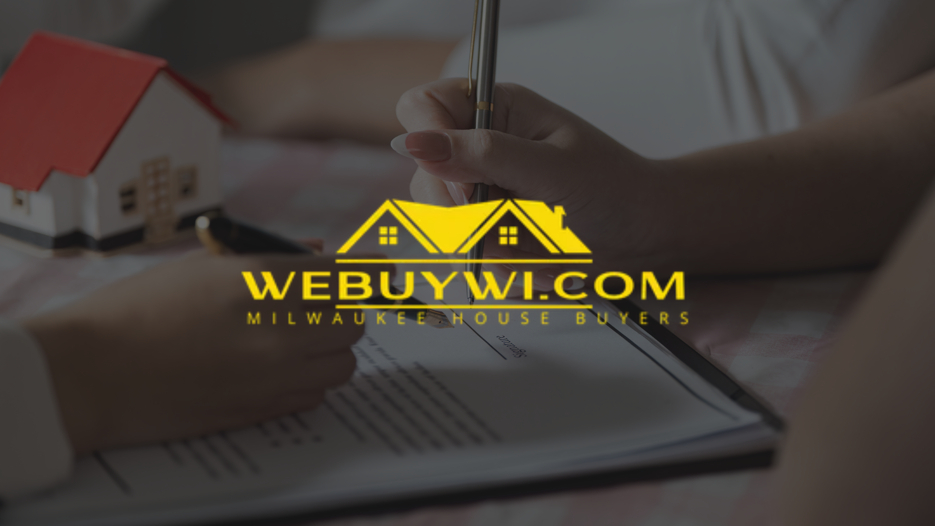 A person is writing on a piece of paper with the website webuywi.com in the background