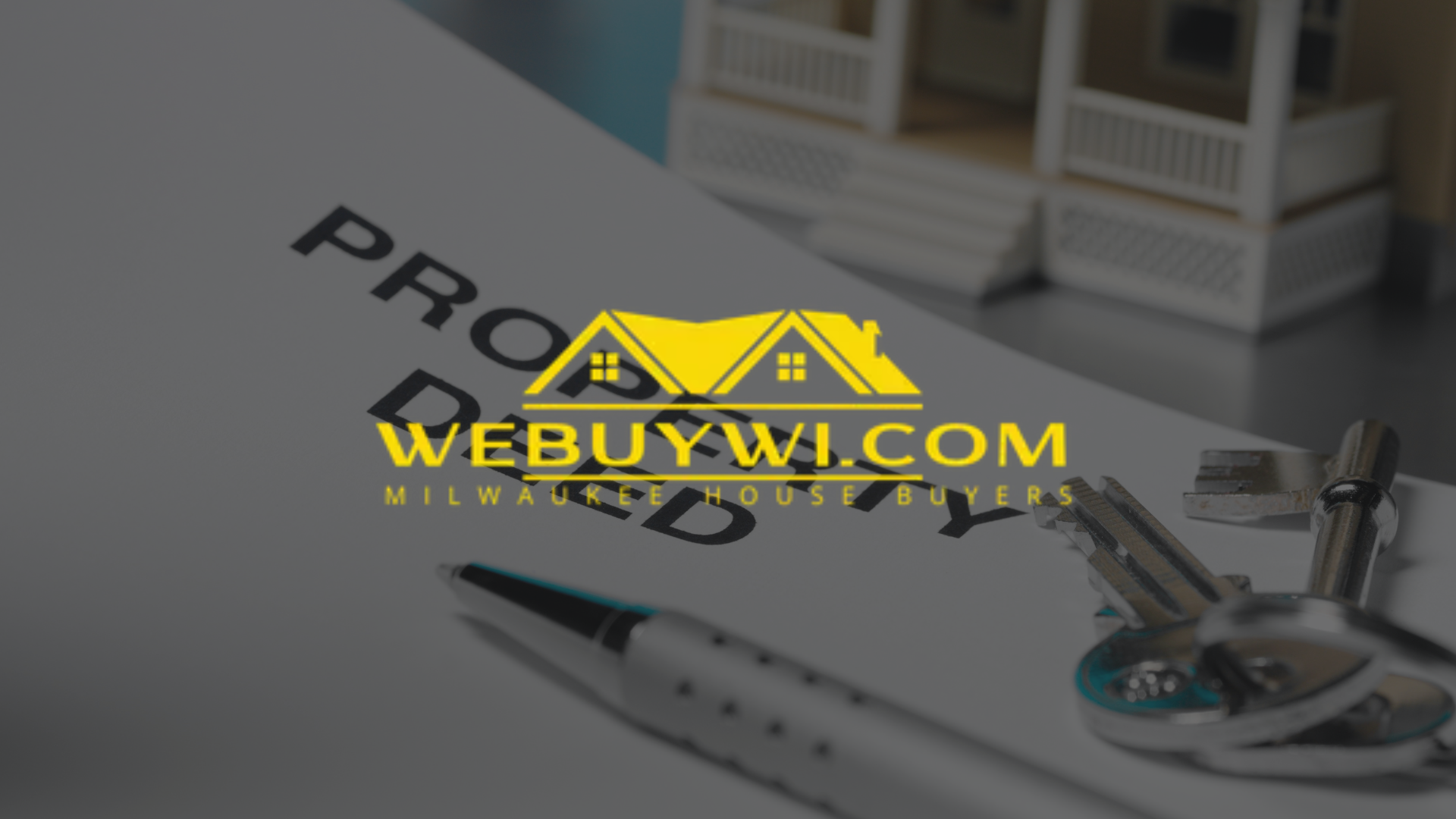 A pen and keys are on a piece of paper that says property deed