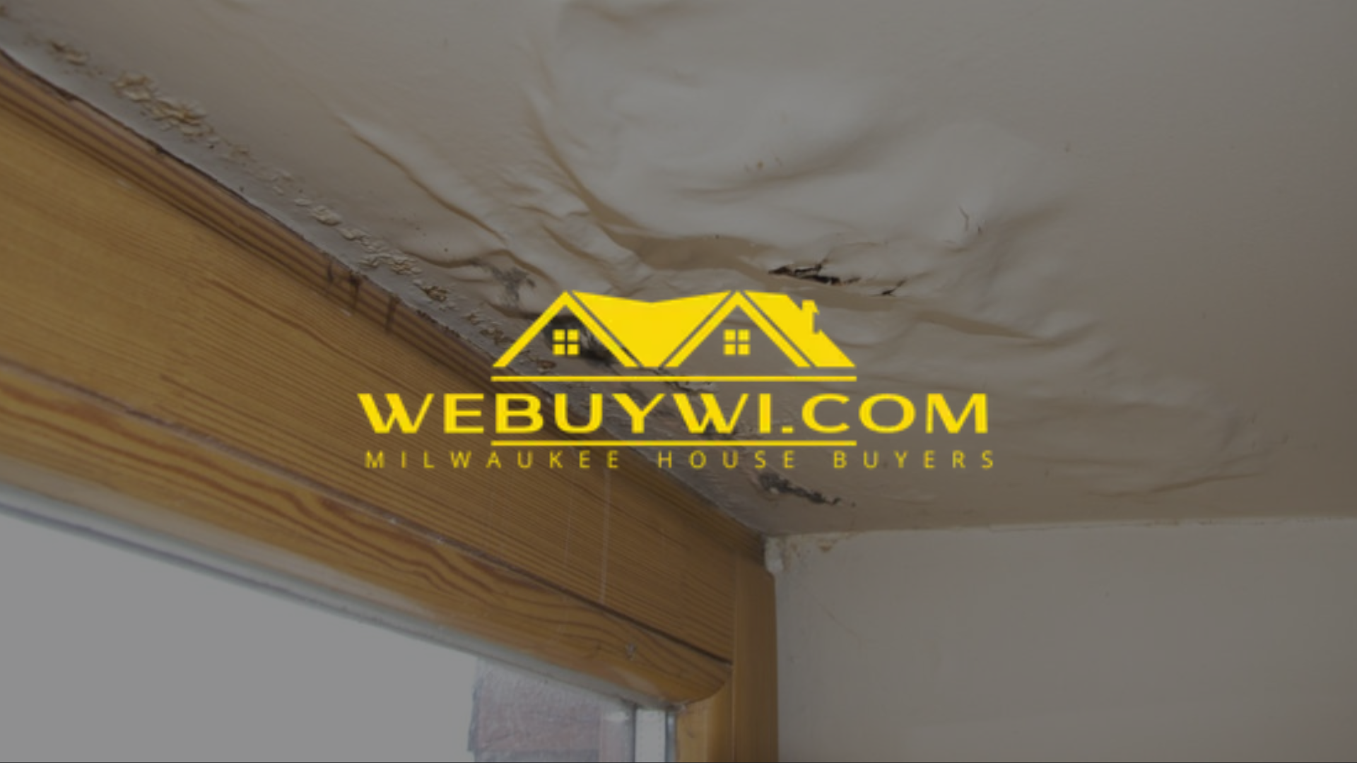 Water-damaged ceiling with peeling paint in greenfield wi near a wooden beam and window frame, indicative of a leak.