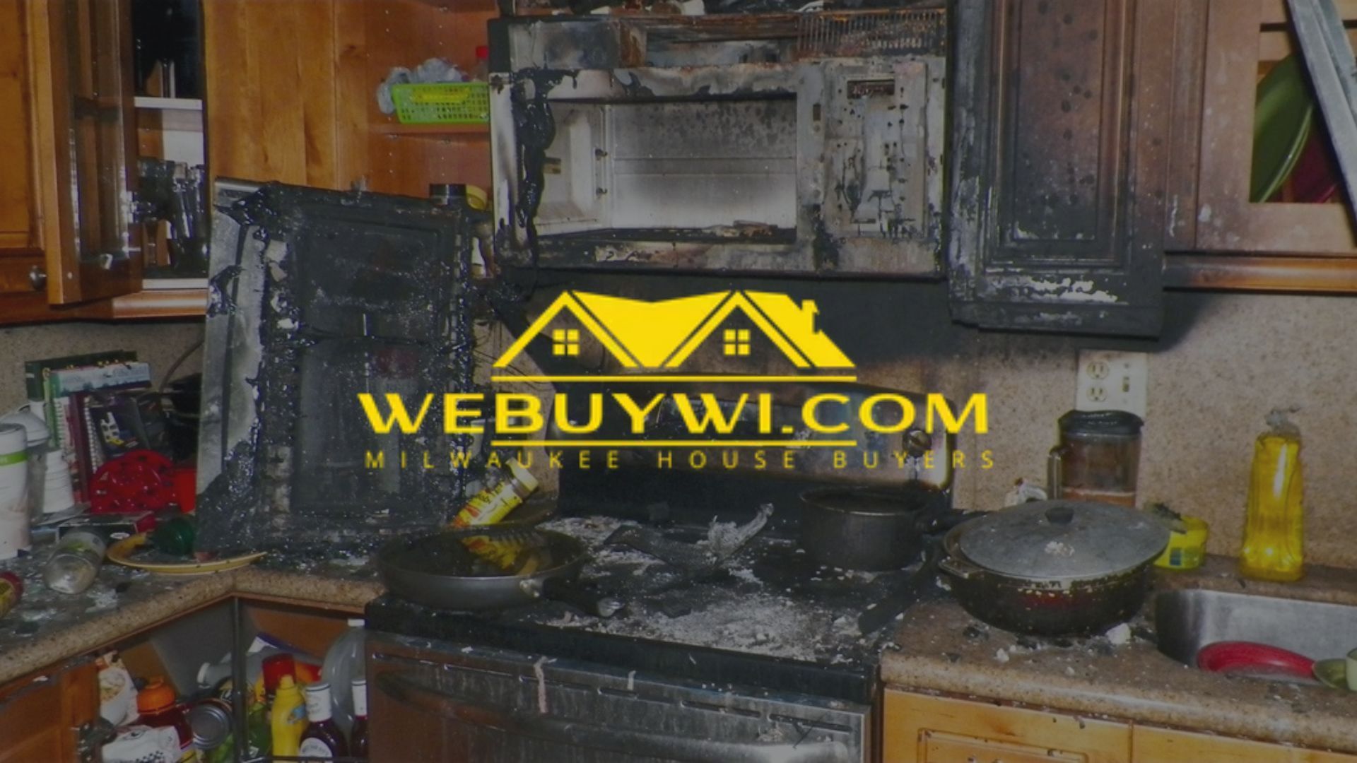 Kitchen interior damaged by fire, stove and cabinets charred.
