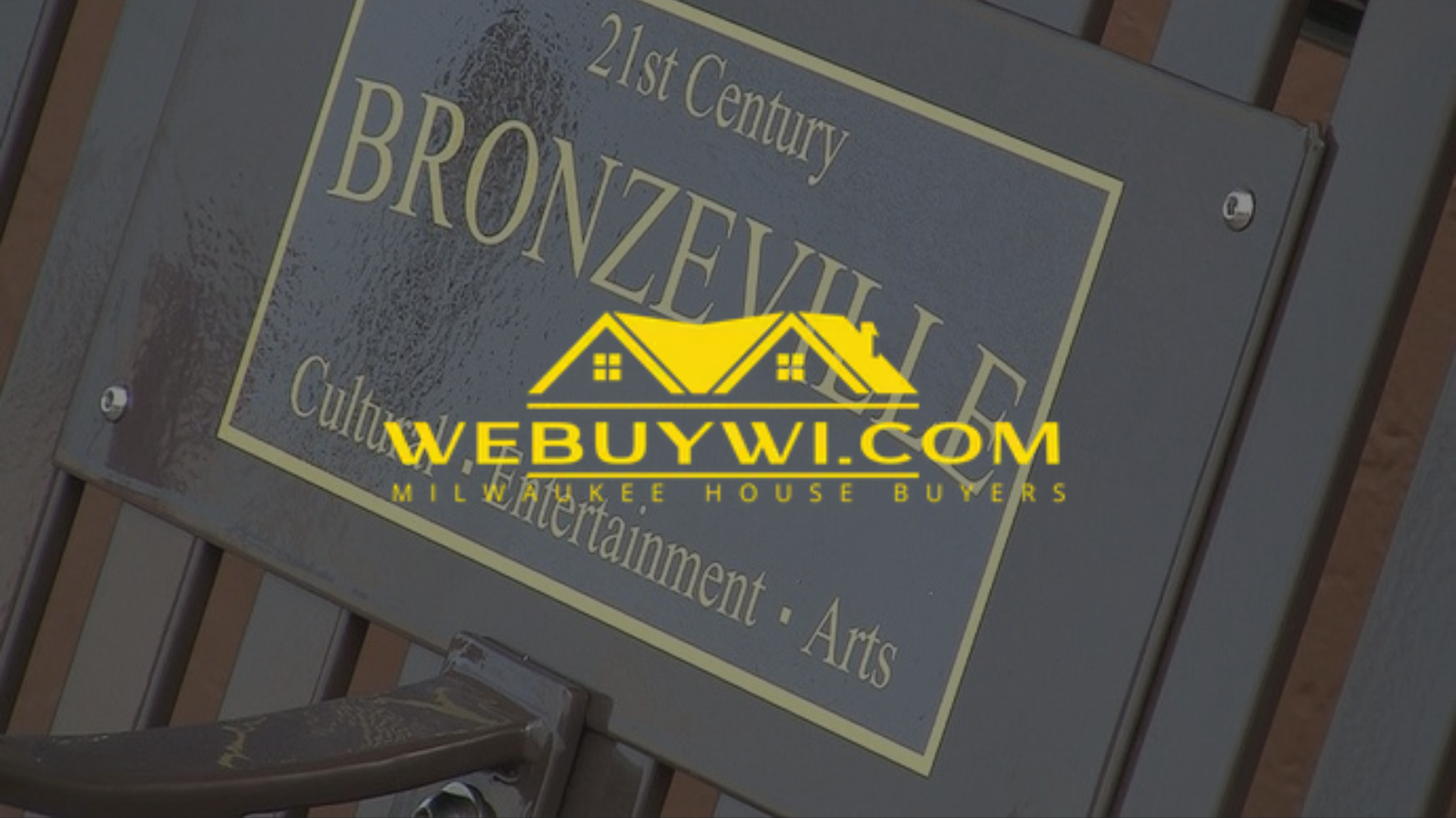 Bronzeville sign on a bench with the WeBuyWI.com logo overlaid. Black and gold color scheme.