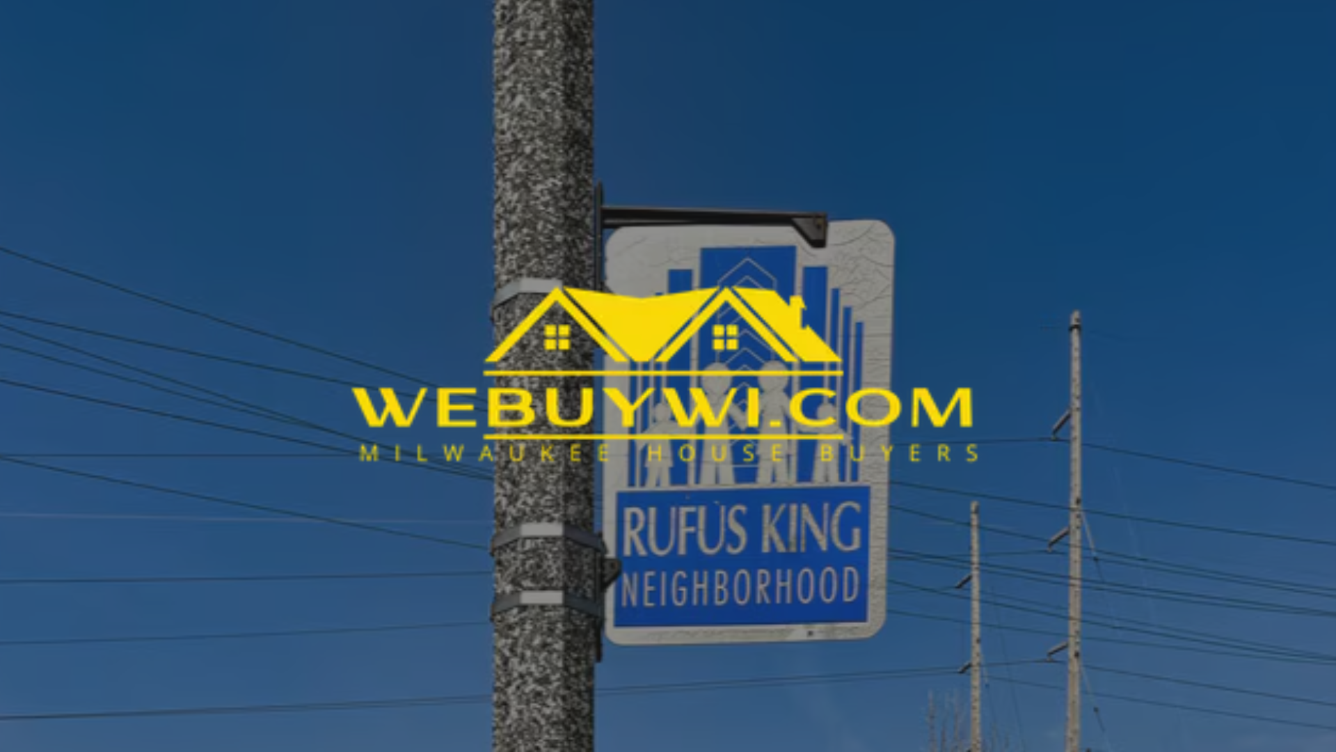 Sign for Rufus King Neighborhood on a pole, blue sky background.