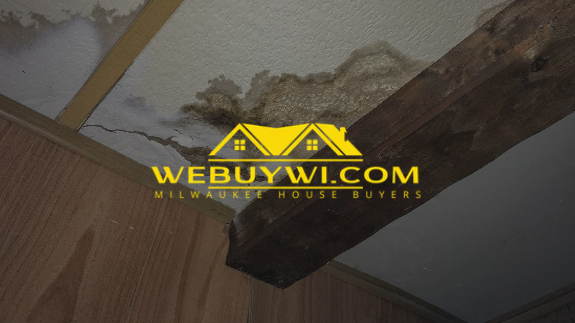 Water damage on a ceiling, with visible discoloration and staining on the wood beam and surrounding drywall. The logo for WeBuyWI.com is overlaid.