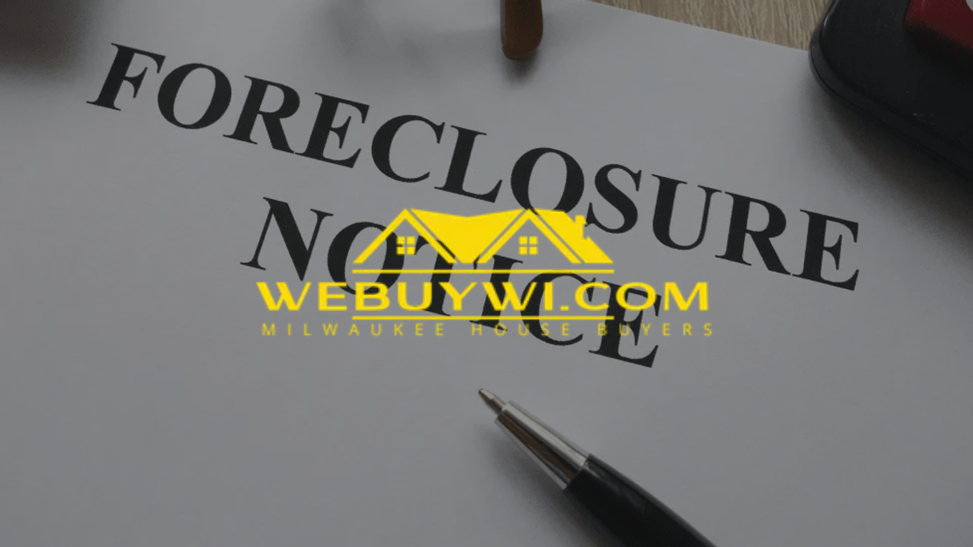 A pen is sitting on top of a piece of paper that says foreclosure with webuywi.com logo on top