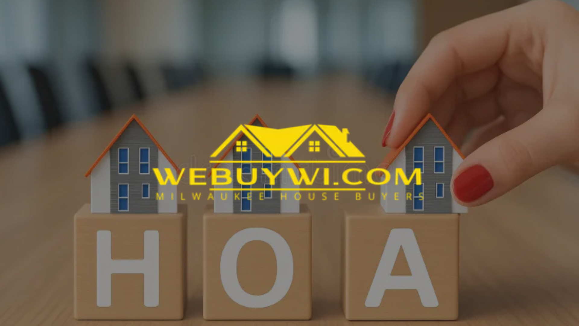 Hand placing a miniature house on a block spelling 