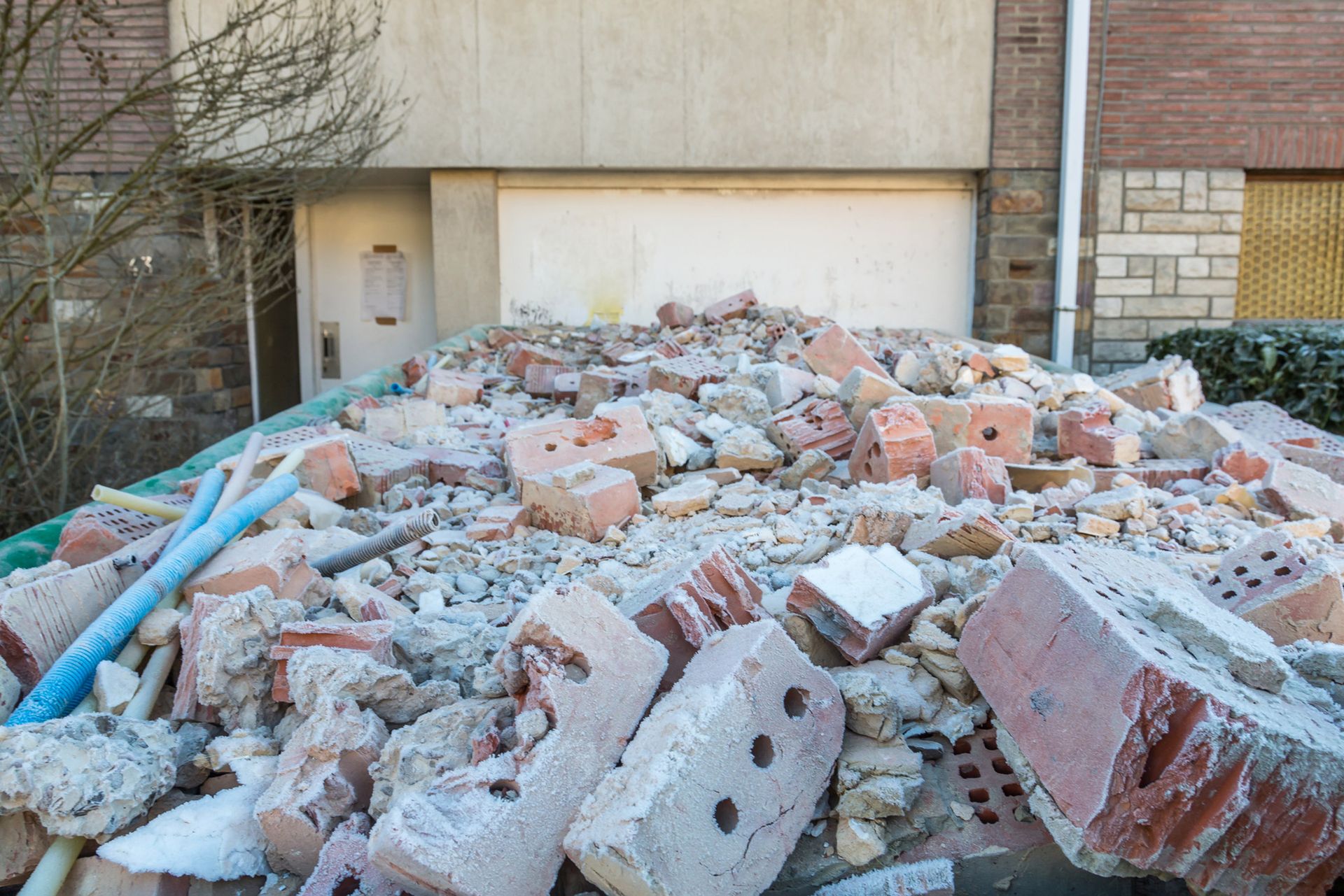 A pile of bricks is sitting in front of a brick building.