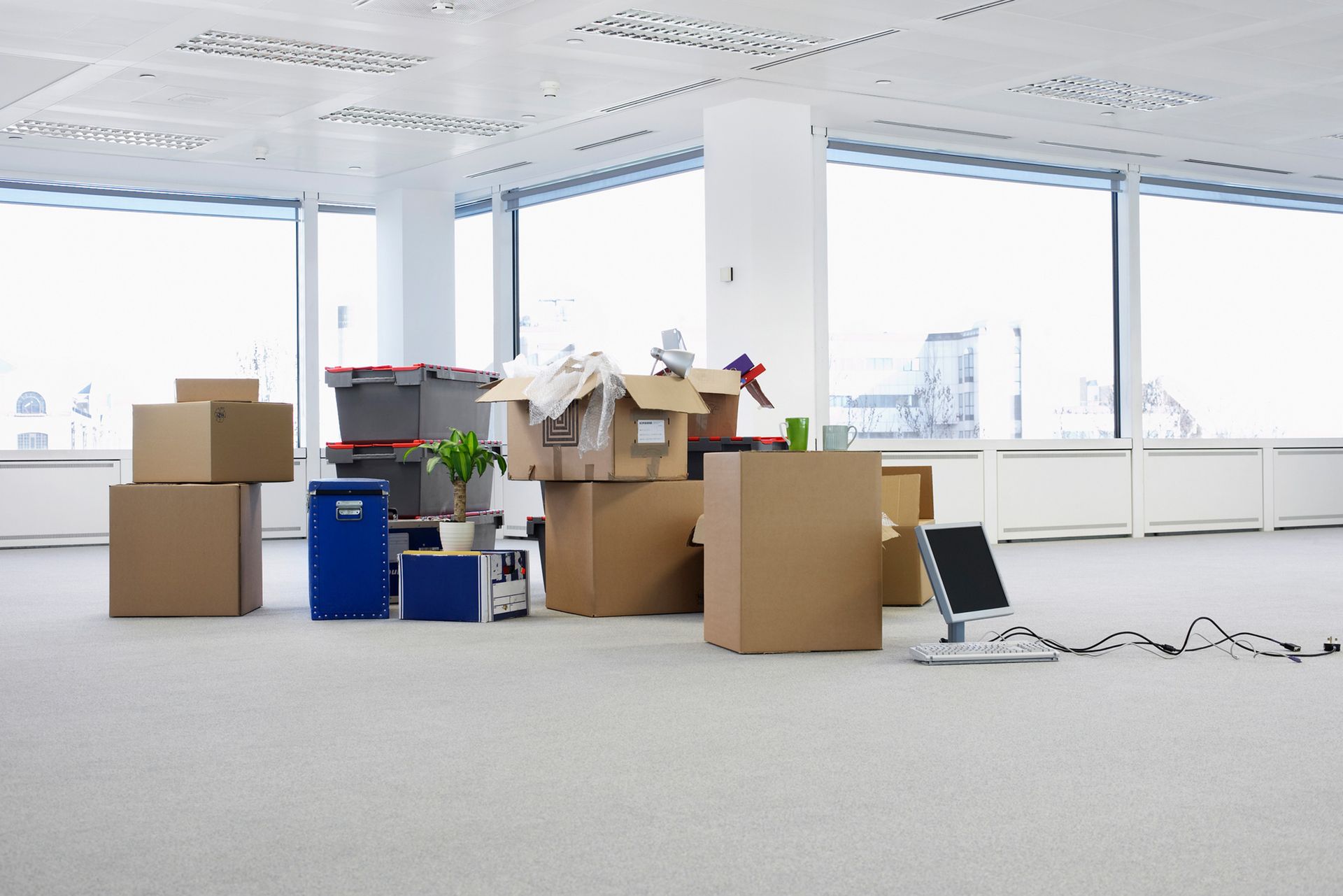 An empty office with boxes and a computer on the floor.