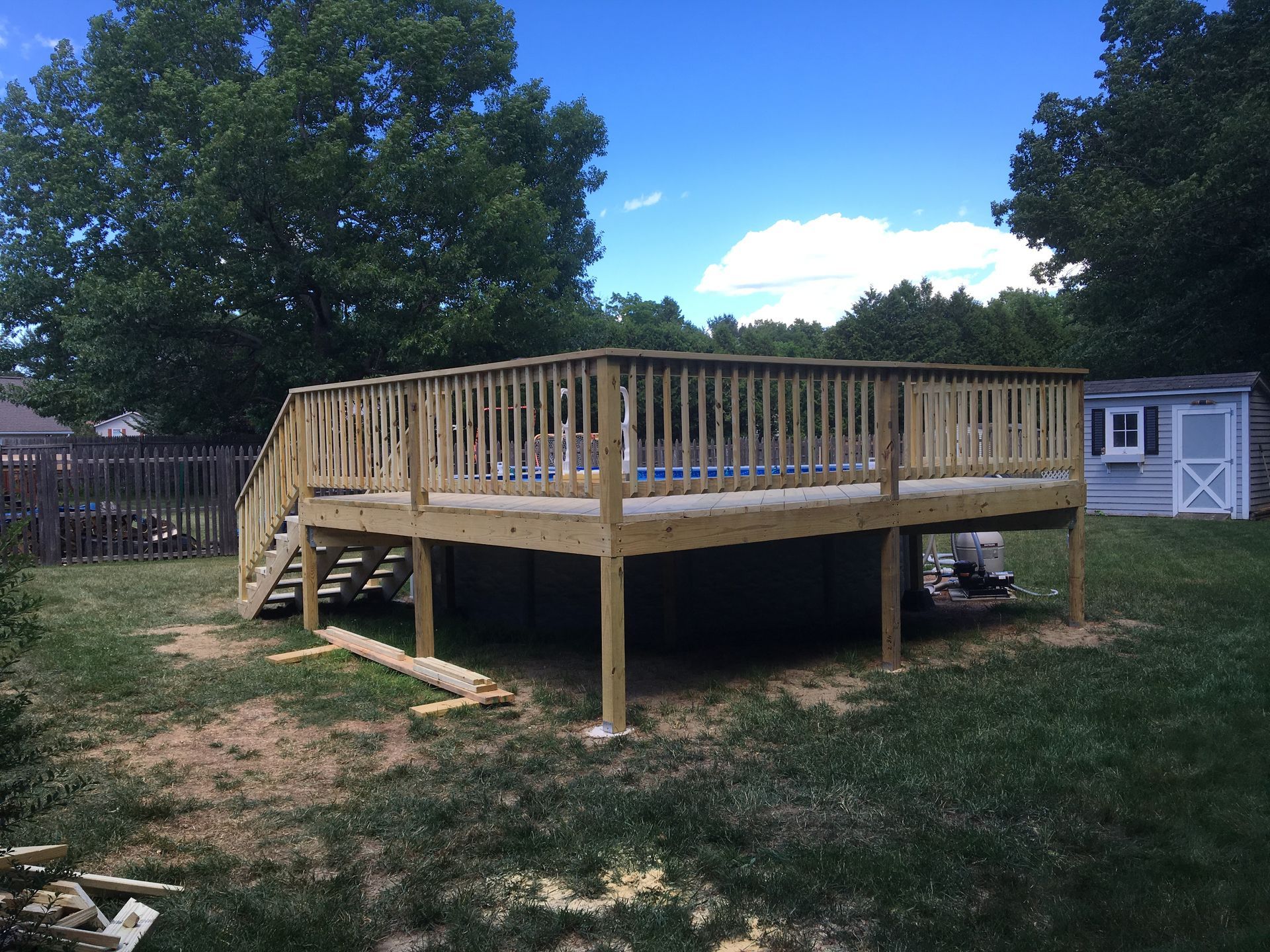 A large wooden deck is being built in a backyard.