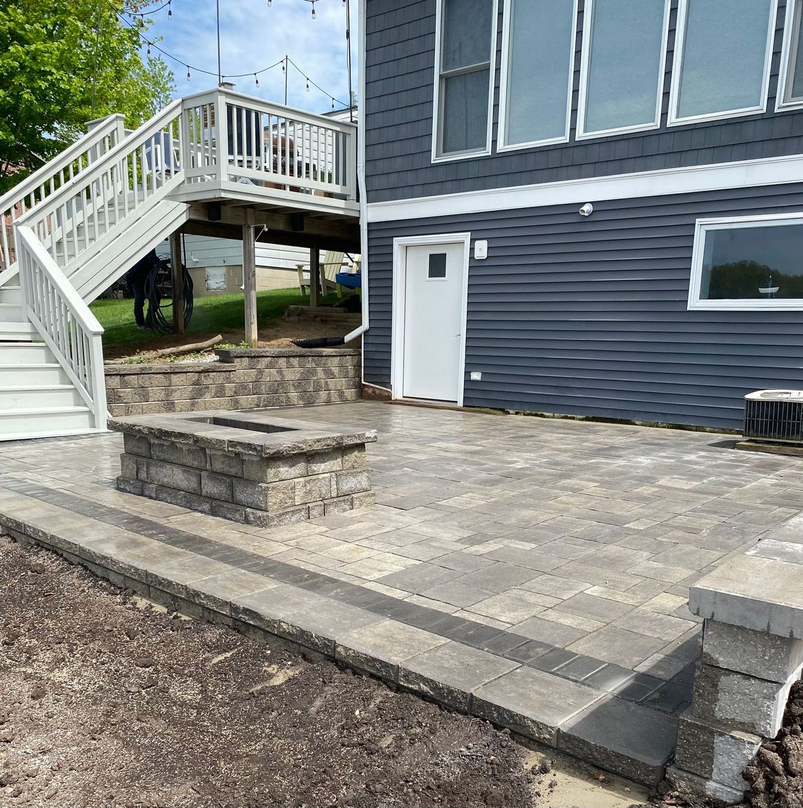 A house with a patio and stairs in front of it.