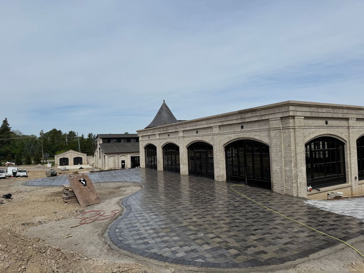 A large brick building with arched windows is under construction.