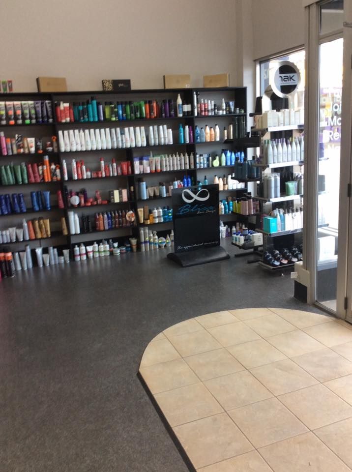 Salon interior with shelves of hair products and a tile entry area.