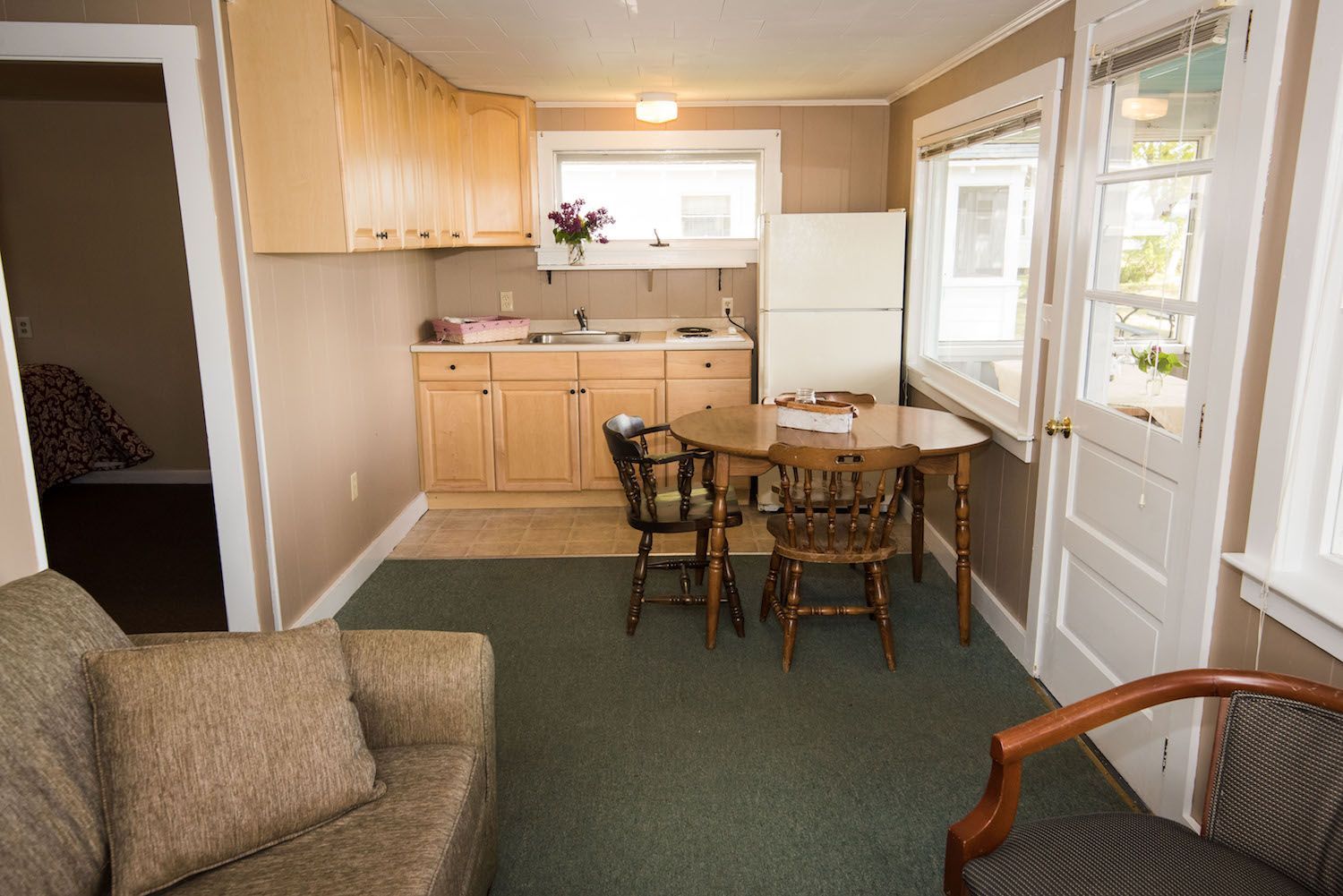 A living room with a table and chairs and a refrigerator