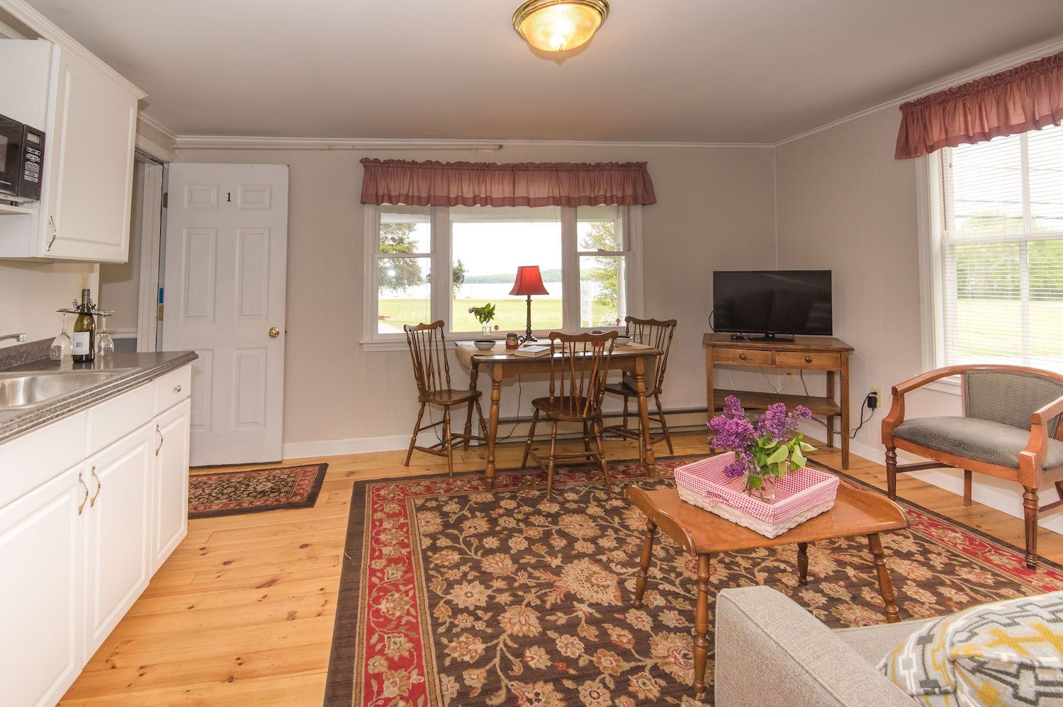 A living room with a couch , table , chairs and a television.