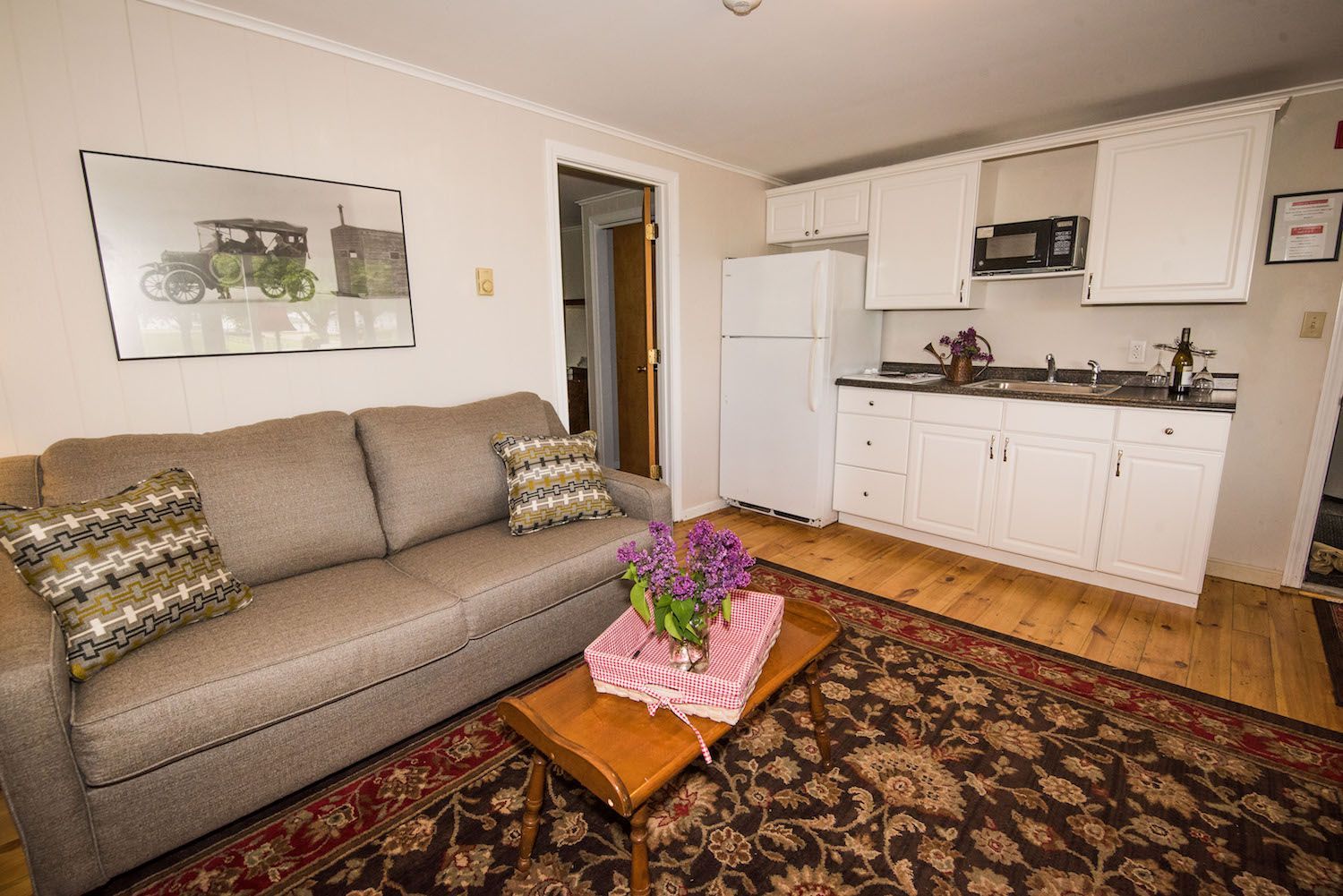 A living room with a couch , coffee table , and kitchen.